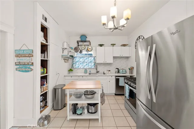 a kitchen with stainless steel appliances granite countertop a refrigerator a stove a sink and dishwasher