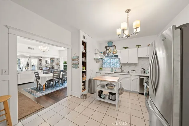 a kitchen with stainless steel appliances a table chairs and a refrigerator