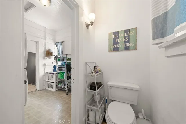 a white toilet sitting next to a bathroom sink and a mirror