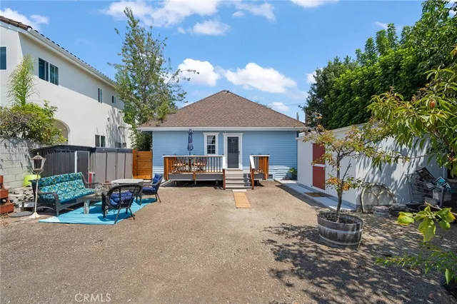 a view of a backyard with sitting area and tree