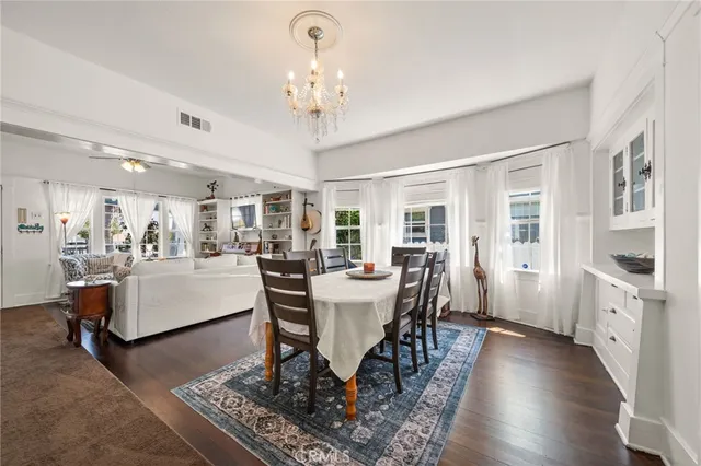a view of a dining room with furniture a chandelier and wooden floor