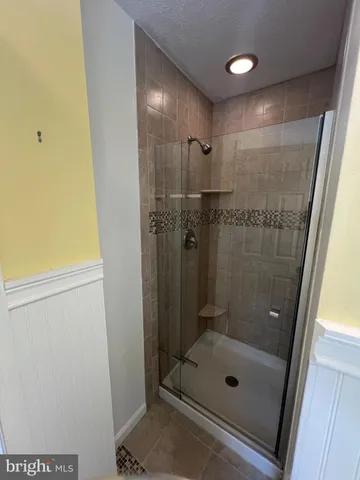 an empty room with a chandelier fan and windows