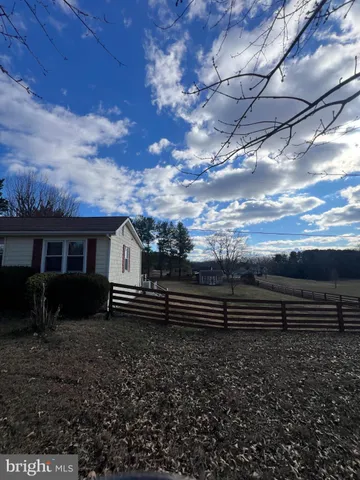 a view of a yard with wooden fence