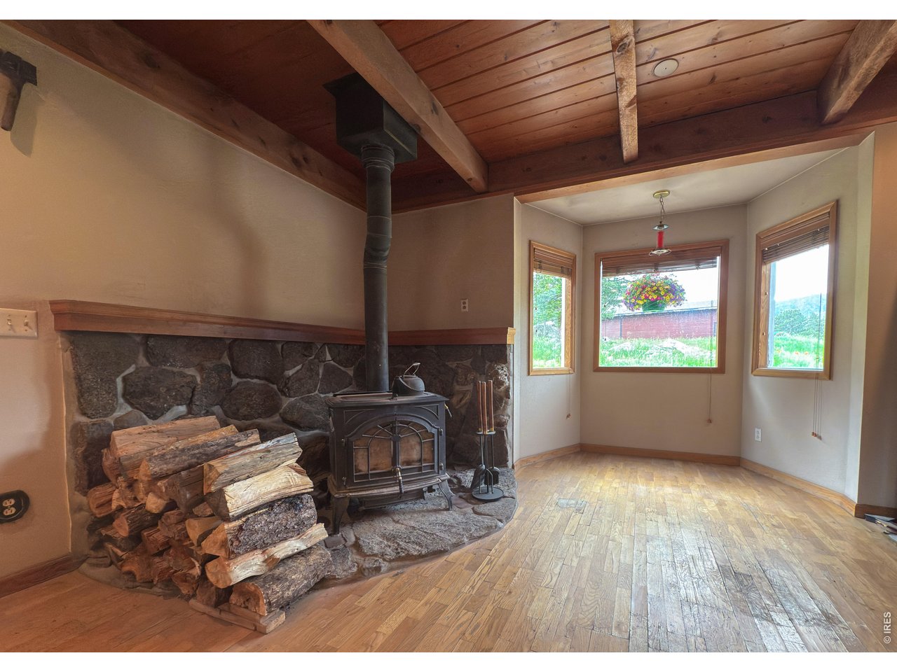 14884 Rist Canyon Road Bellvue, CO 80512 - Photo 12 of 50 a view of an empty room with wooden floor fireplace and a window