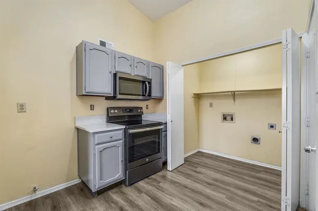 a kitchen with stainless steel appliances a stove a microwave a sink and a refrigerator