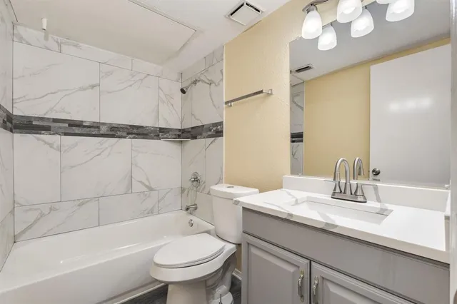 a bathroom with a sink a toilet a mirror and shower