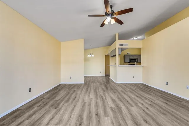 a view of a big room with wooden floor a ceiling fan and a ceiling fan