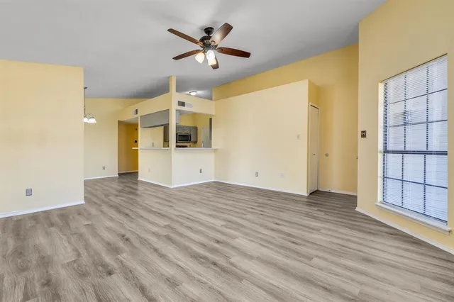 a view of a kitchen with wooden floor and a ceiling fan