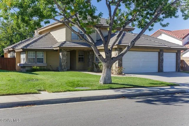 a front view of a house with a yard and trees