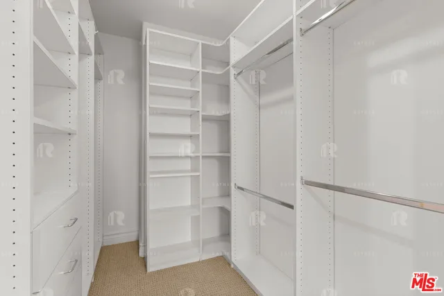 a view of walk in closet with empty racks