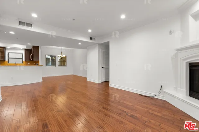 a view of a big room with wooden floor and a fireplace