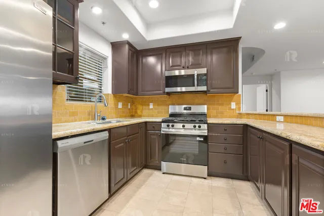 a kitchen with stainless steel appliances granite countertop a sink and stove top oven