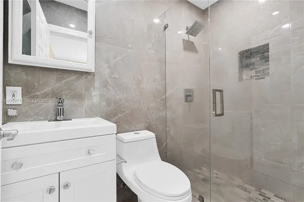 a bathroom with a toilet sink vanity and shower