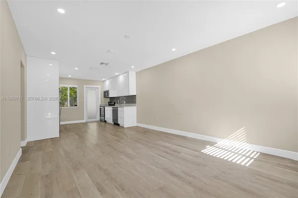 a view of empty room with wooden floor