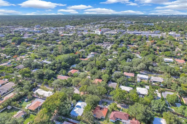 an aerial view of residential houses with outdoor space and trees