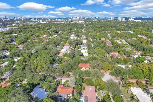 an aerial view of residential houses with outdoor space and trees