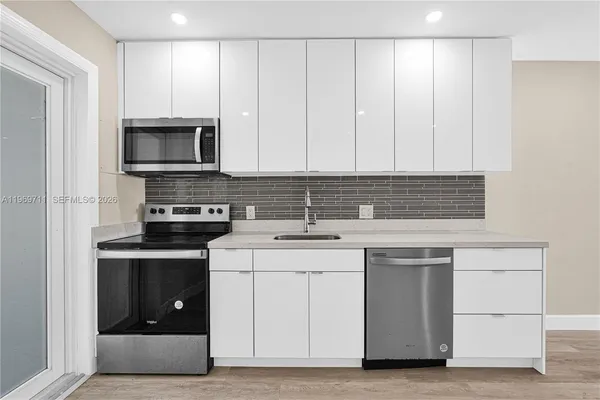 a kitchen with stainless steel appliances granite countertop a stove a sink and a microwave