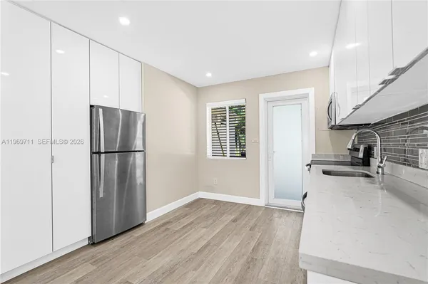 a kitchen with stainless steel appliances granite countertop a refrigerator a stove and a sink