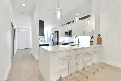 a large white kitchen with cabinets