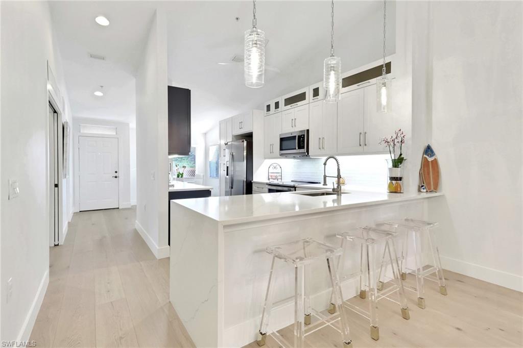 2386 Magnolia Avenue, Unit 7816 Naples, FL 34112 - Photo 1 of 28 a large white kitchen with cabinets