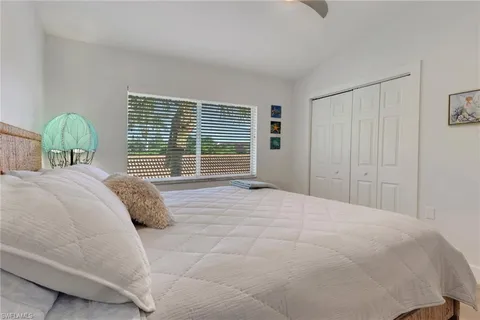 a bedroom with a bed and a large window