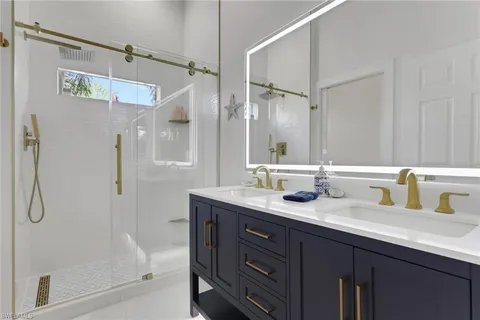 a bathroom with a granite countertop sink mirror shower and double