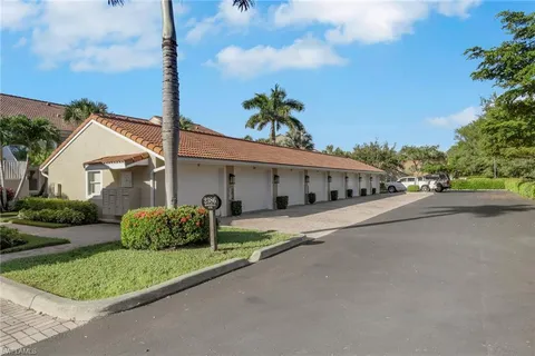 a front view of a house with a garden and trees