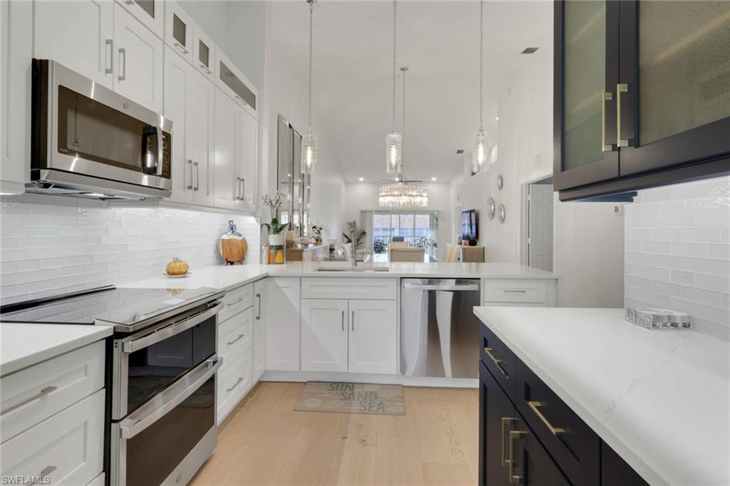 2386 Magnolia Avenue, Unit 7816 Naples, FL 34112 - Photo 2 of 28 a kitchen with a sink a stove and microwave