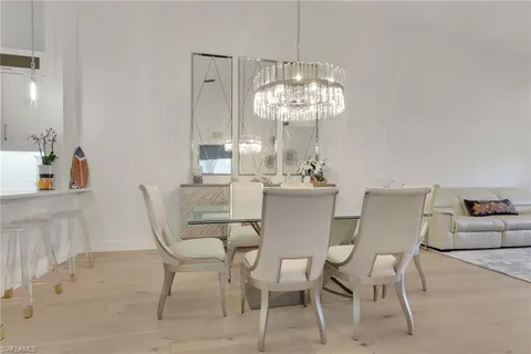a view of a dining room with furniture a chandelier and wooden floor