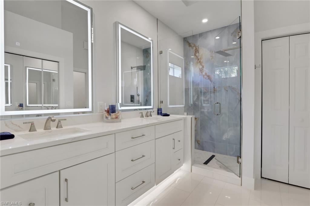 2386 Magnolia Avenue, Unit 7816 Naples, FL 34112 - Photo 10 of 28 a bathroom with double sink and a mirror