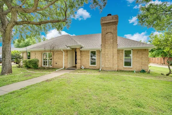 a front view of a house with a garden and yard