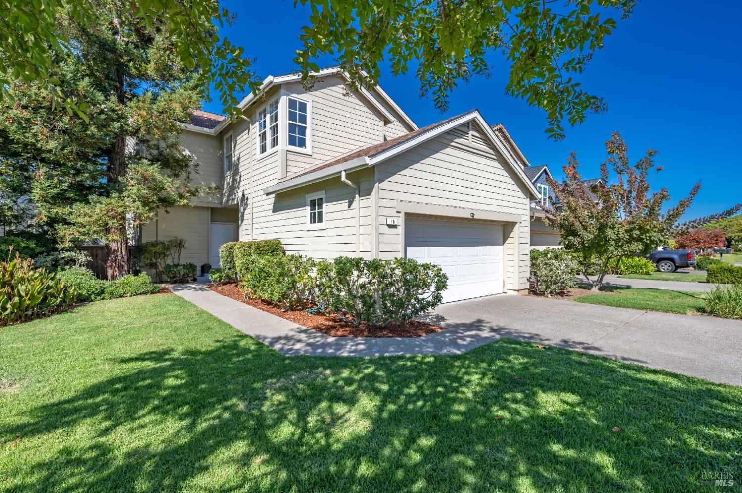 a front view of a house with a yard and potted plants
