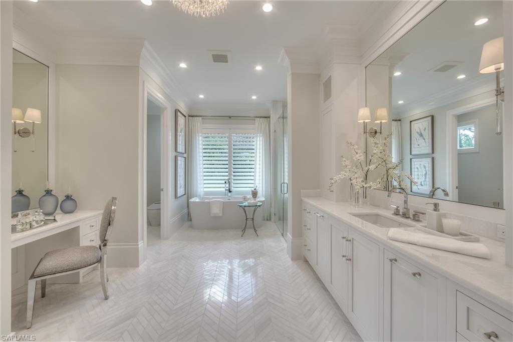 13981 Williston Way Naples, FL 34119 - Photo 9 of 13 a large bathroom with a double vanity sink a mirror and a bathtub