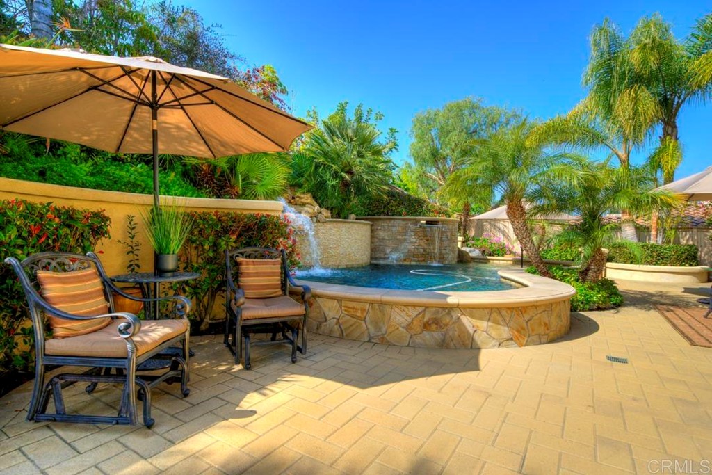 2887 Rancho Cortes Carlsbad, CA 92009 - Photo 6 of 46 a view of a patio with table and chairs under an umbrella