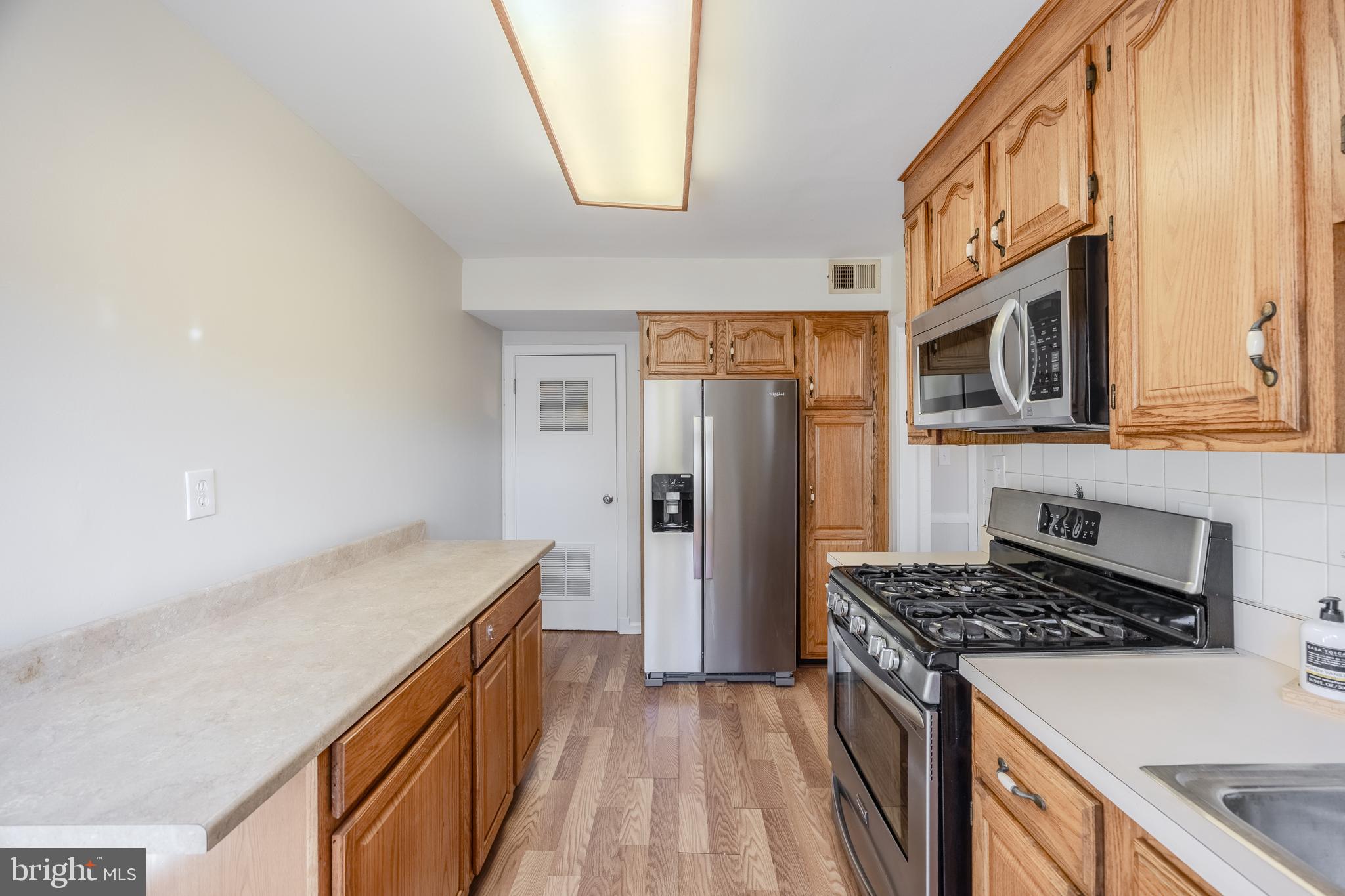 60 Garden Ridge Road Baltimore, MD 21228 - Photo 17 of 39 a kitchen with a stove and a refrigerator