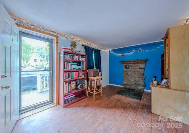 a view of an empty room with window and wooden floor