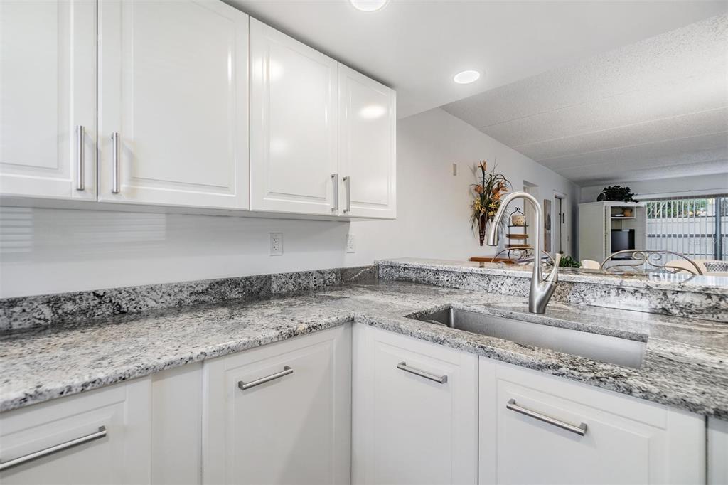 12760 Indian Rocks Road, Unit 104 Largo, FL 33774 - Photo 6 of 37 a kitchen with granite countertop a sink and cabinets