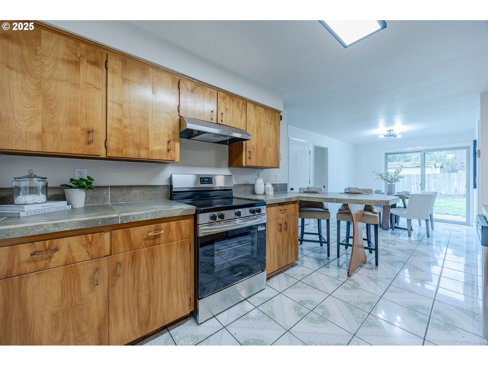 5982 G Street Springfield, OR 97478 - Photo 12 of 39 a kitchen with stainless steel appliances granite countertop a stove a sink a dining table and chairs