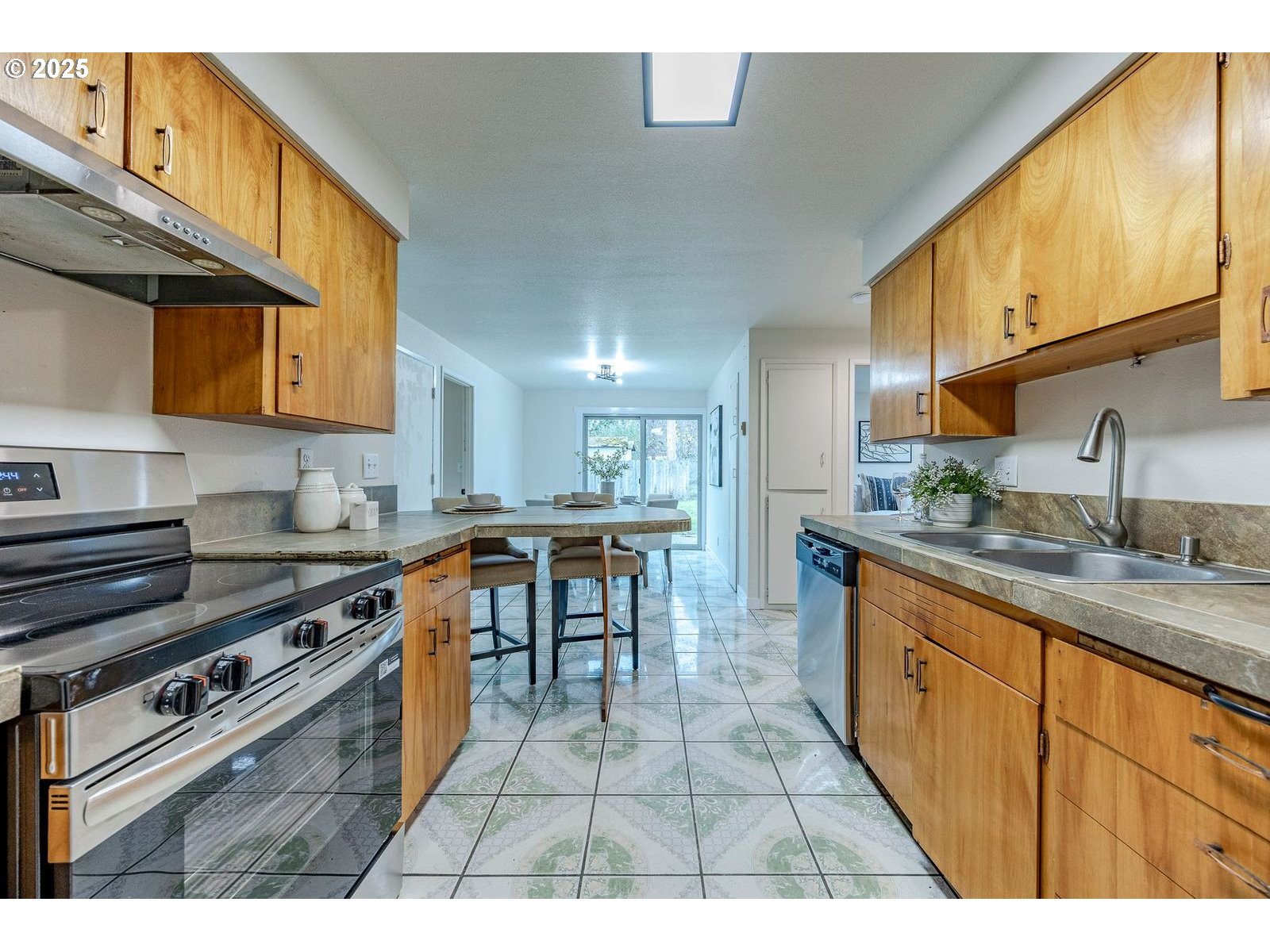 5982 G Street Springfield, OR 97478 - Photo 14 of 39 a kitchen with kitchen island granite countertop a sink cabinets and stainless steel appliances