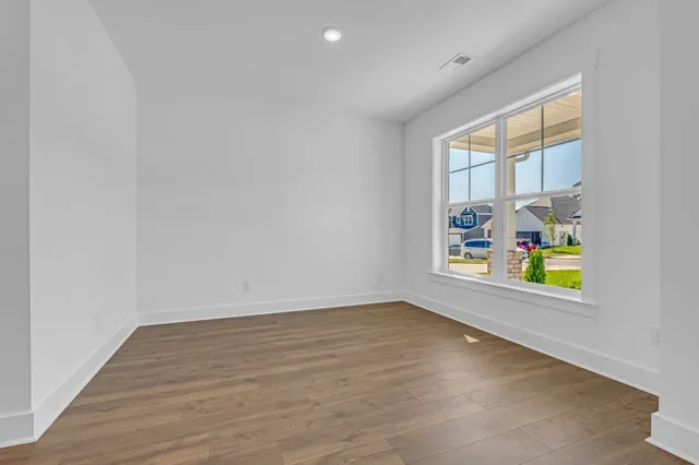 wooden floor in an empty room with a window