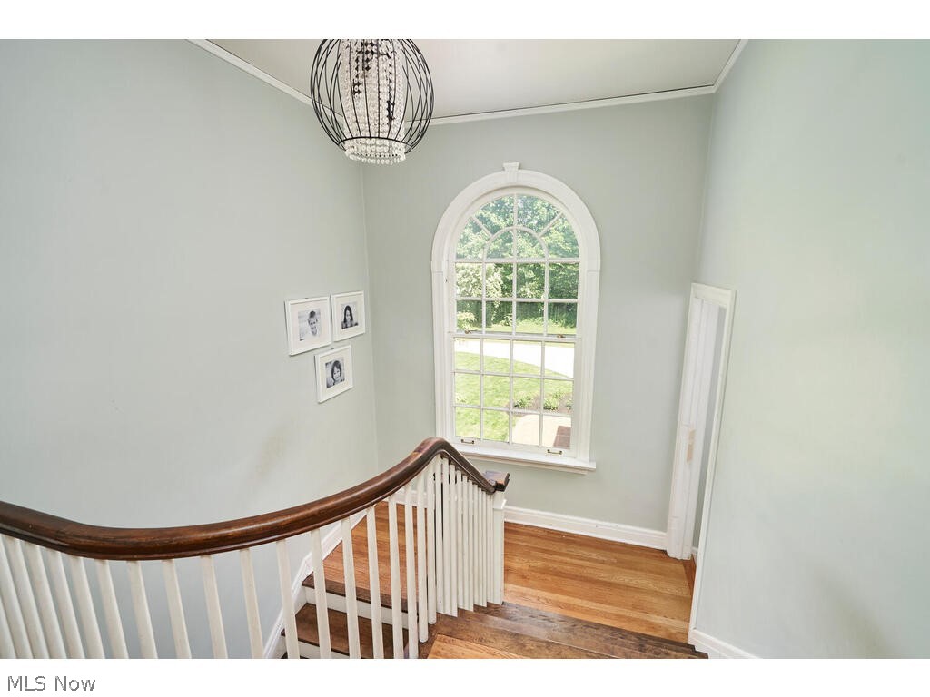 39 North Wheaton Road Akron, OH 44313 - Photo 20 of 38 Stairs featuring wood-type flooring, a towering ceiling, an inviting chandelier, and crown molding