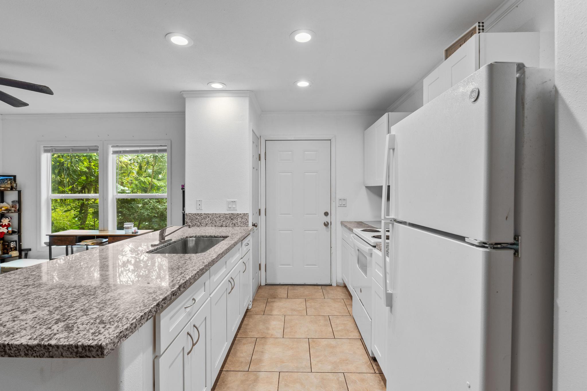 14-823 Seaview Road Pahoa, HI 96778 - Photo 6 of 23 a kitchen with granite countertop a refrigerator and a sink