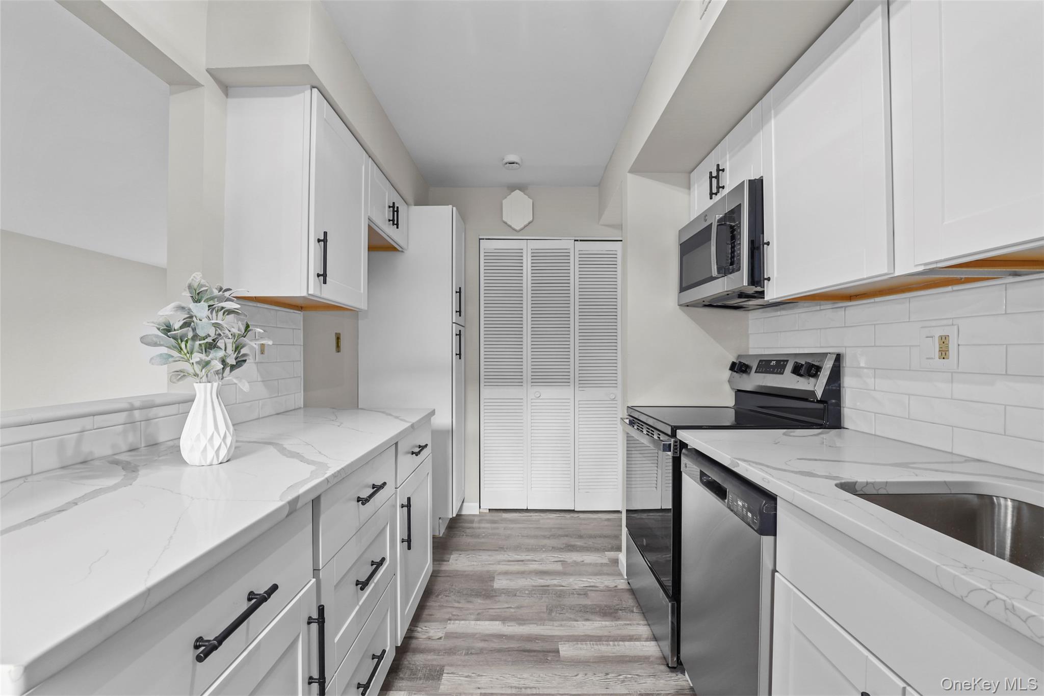 208 Harris Road, Unit D4A Bedford Hills, NY 10507 - Photo 2 of 13 a kitchen with granite countertop white cabinets and white appliances