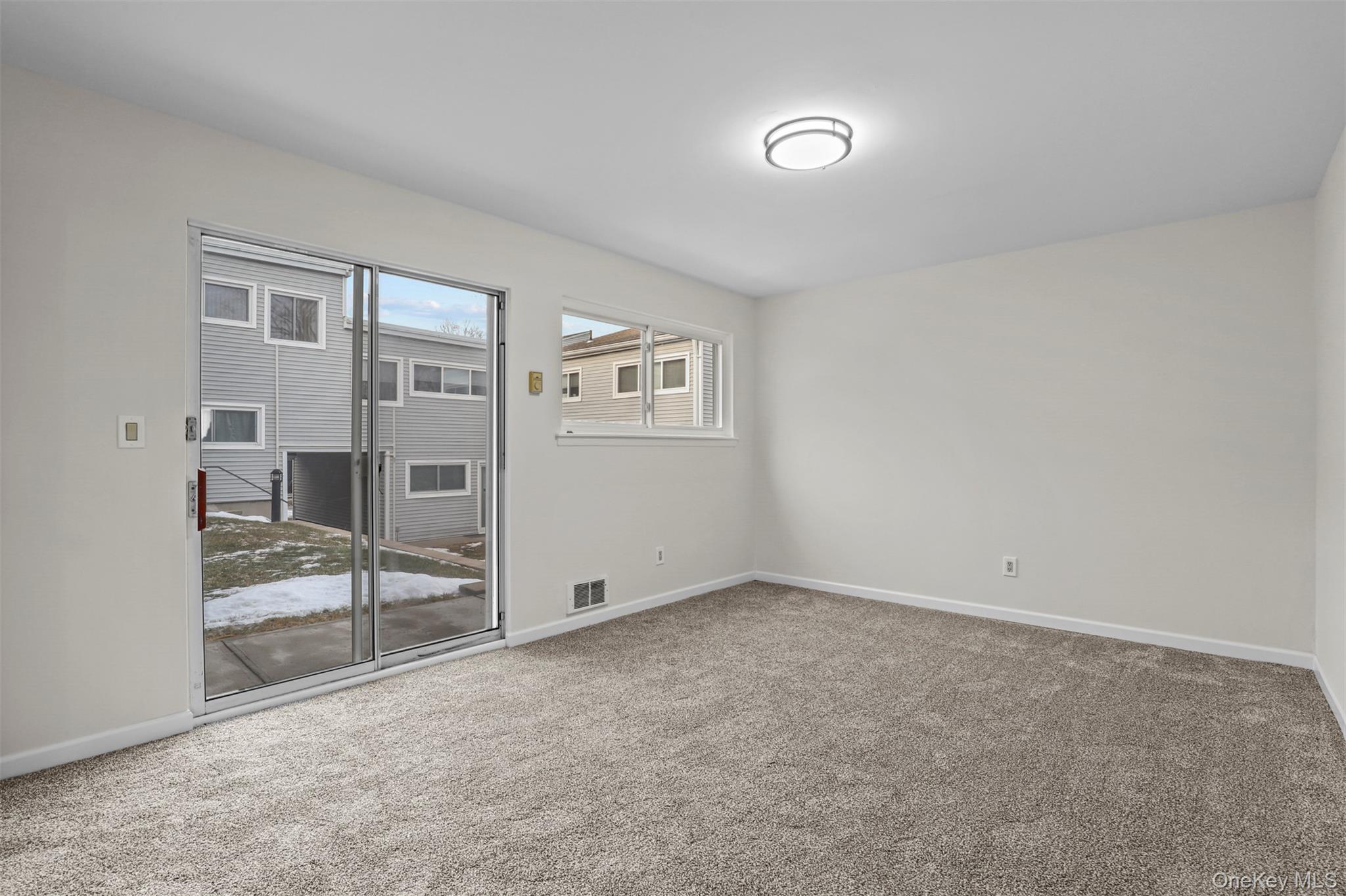 208 Harris Road, Unit D4A Bedford Hills, NY 10507 - Photo 9 of 13 an empty room with windows