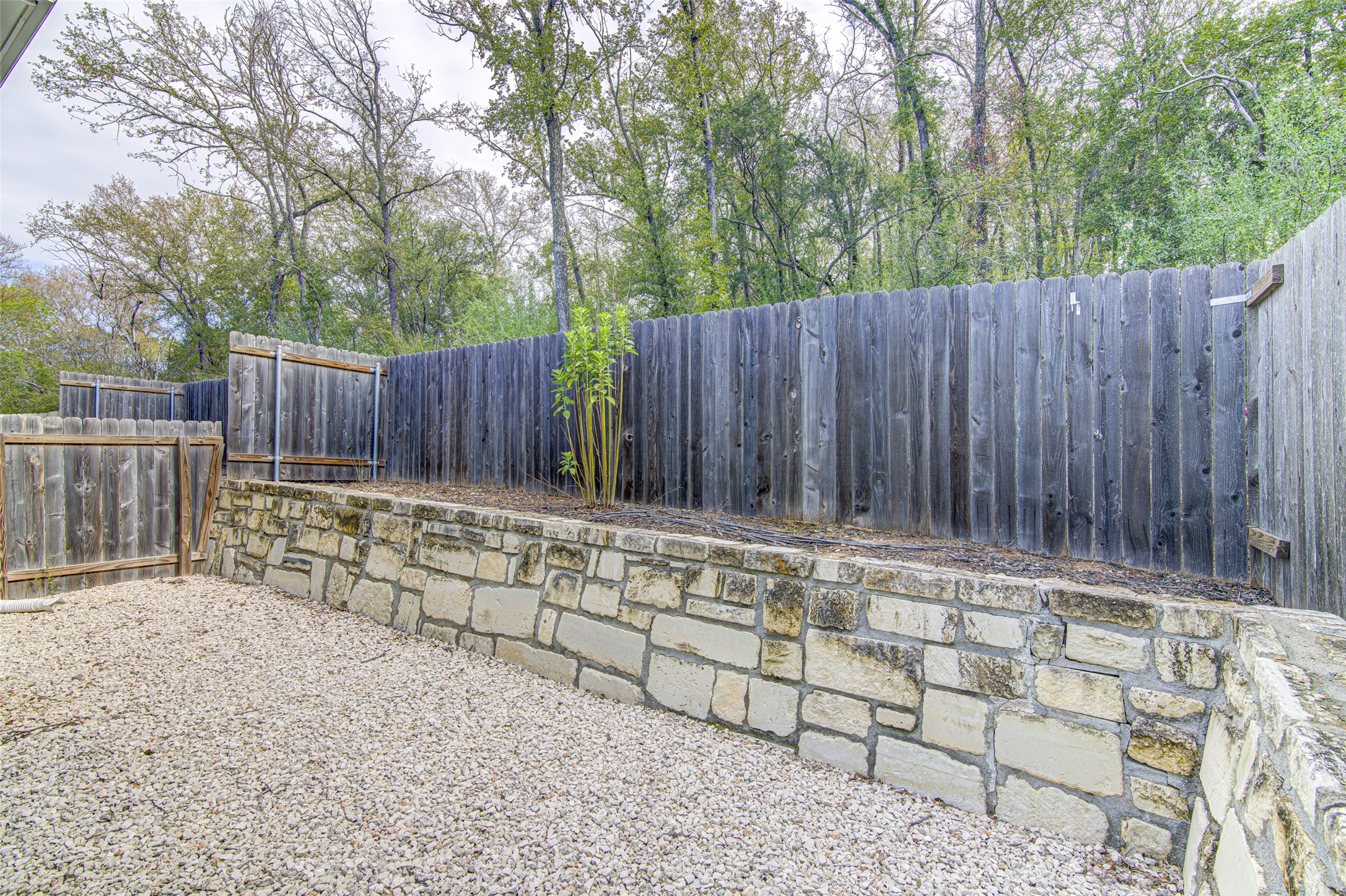 1904 Bunche Road, Unit B Austin, TX 78721 - Photo 25 of 29 Private backyard with a gravel patio, landscaped beds with a drip irrigation system.