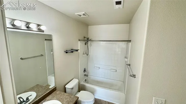 a bathroom with a granite countertop sink toilet a shower and a mirror