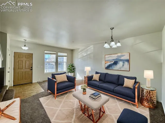 a living room with furniture a chandelier and a window