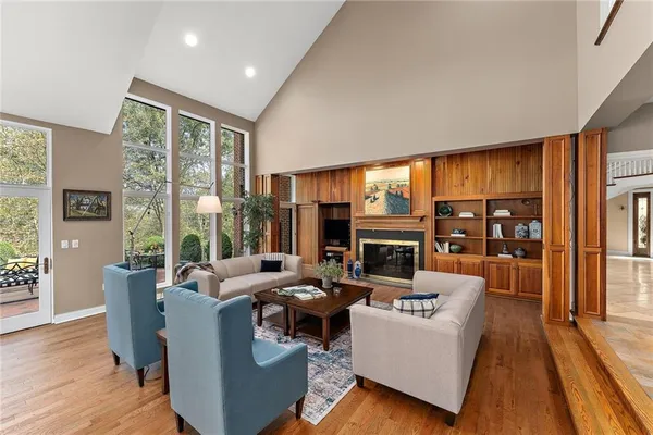 a living room with fireplace furniture and a large window