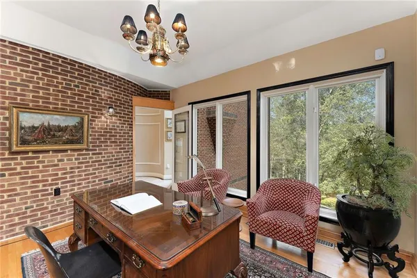 a view of a workspace with furniture and a large window