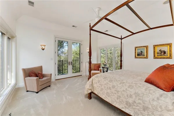 a bedroom with a bed and glass walk in closet